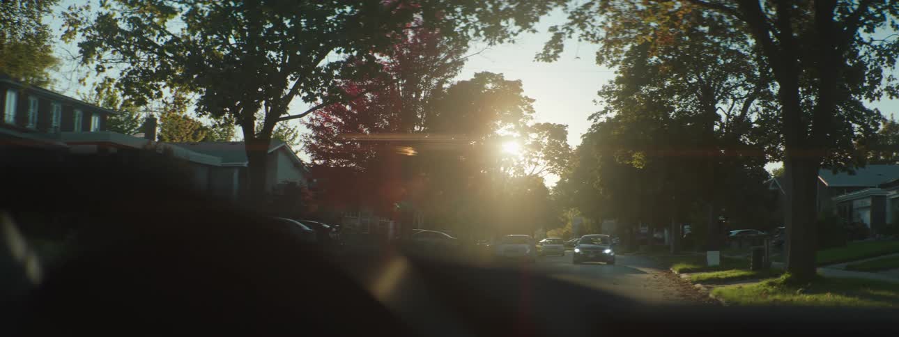 A car drives down the neighborhood street