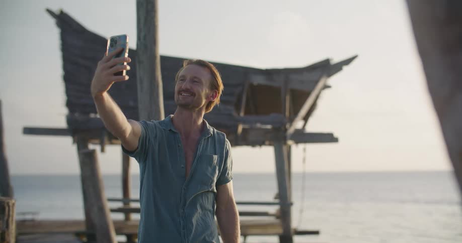A man kissing towards a phone