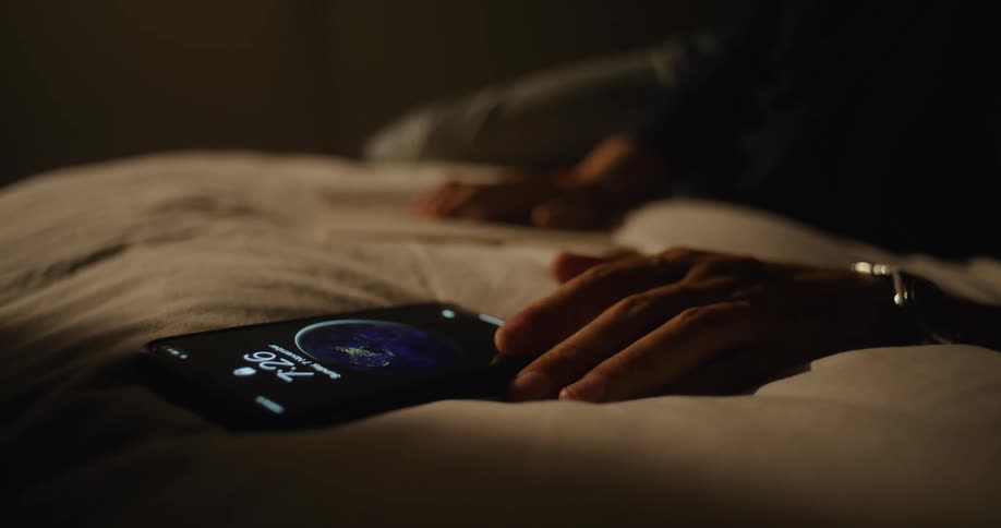 A person writes notes in his book and turns his phone on