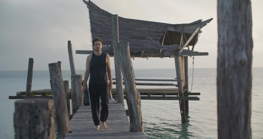 A man walking off a pier and towards the camera