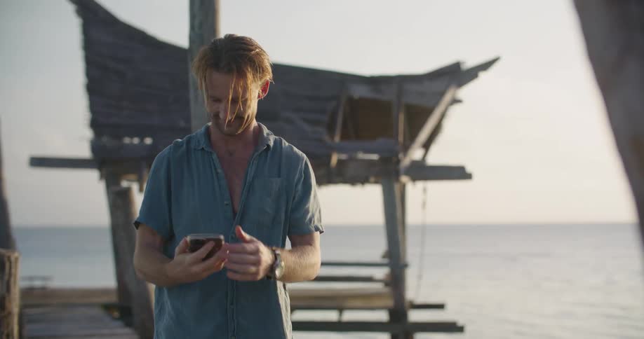 A man takes a selfie by the water