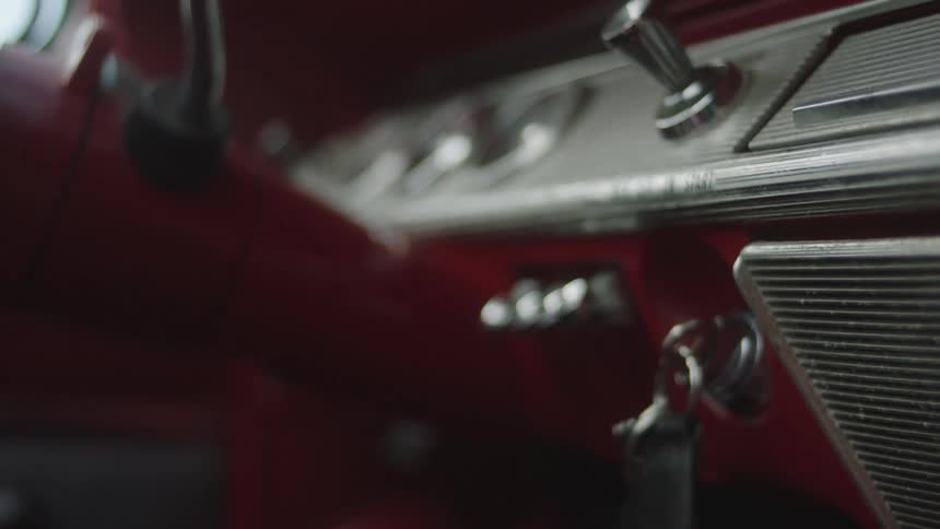 Woman with black leather jacket starts classic car