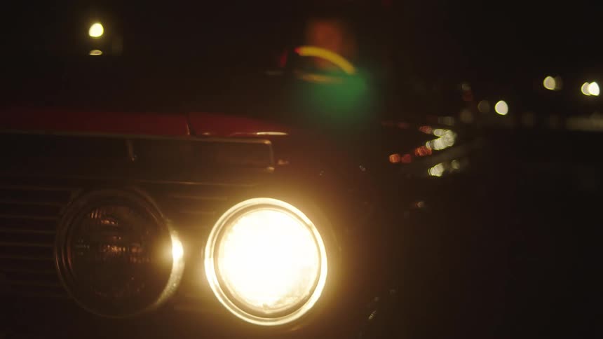 Person starts car turning on headlight at night