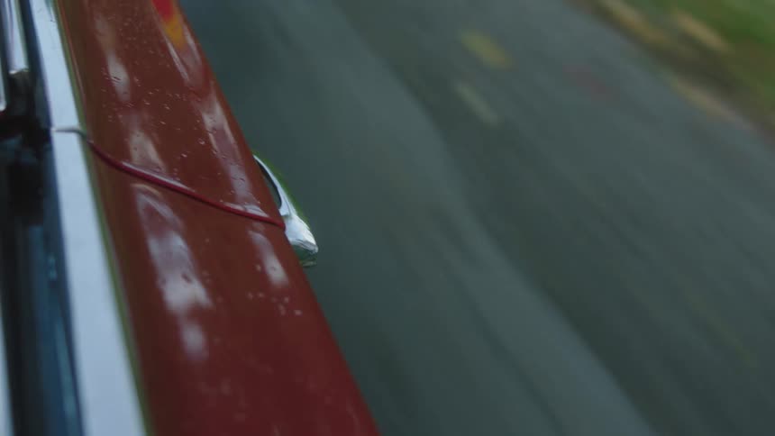 A car is driving down a highway that has broken pavement