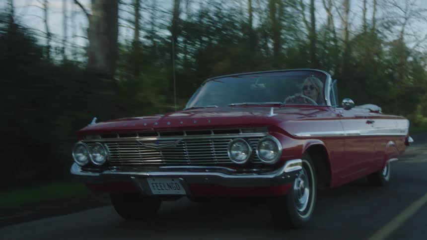 A woman driving a convertible outdoors