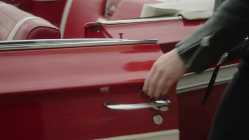 A woman tosses her cigarette on the ground and gets back in her car to drive off
