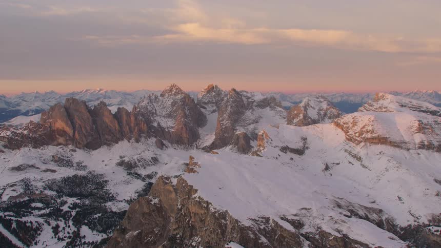 A snow covered mountain range under a dull evening sky