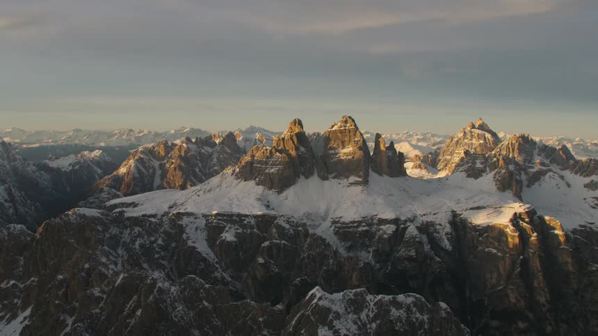 An aerial view of a mountain range with snow on it