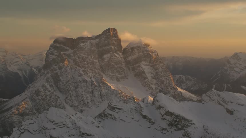 A smoky haze sits over snowy mountains