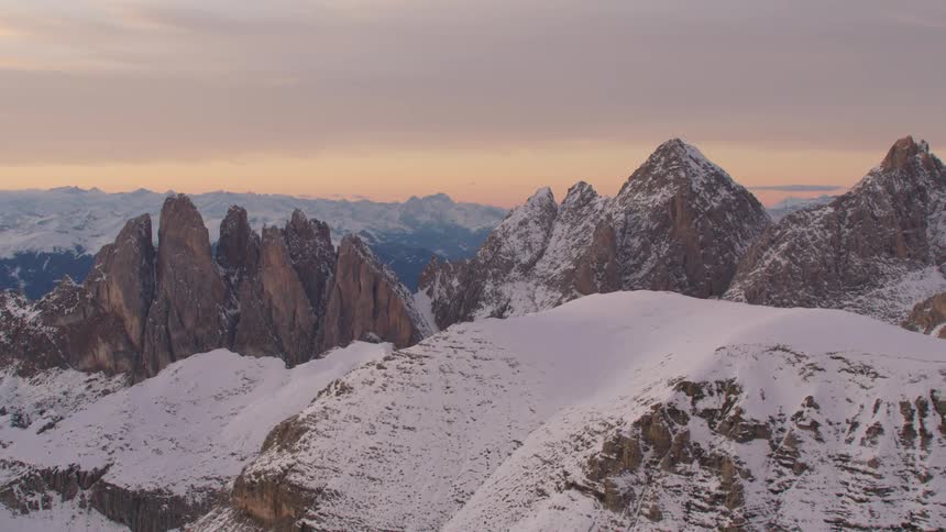 An aerial view of a mountain range with snow on it