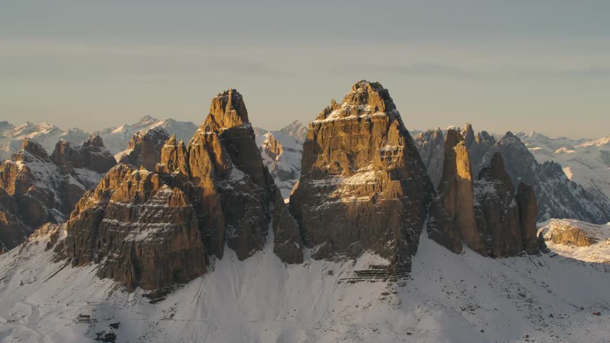 Sunlight shines on peaks that are above the thick snowline in a mountain range