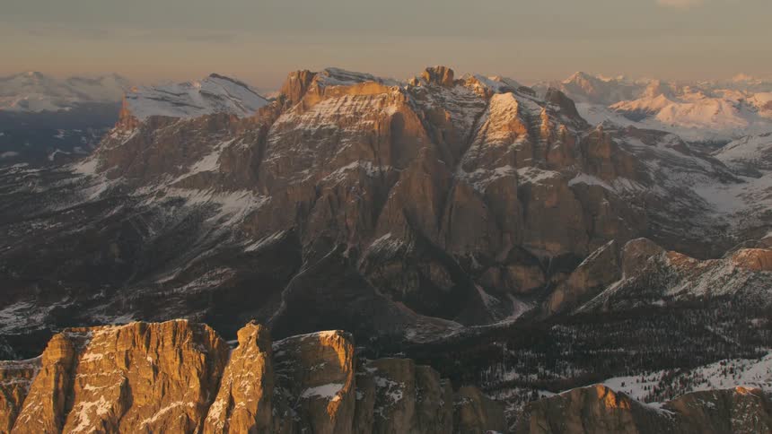 Mountain range and forest partially covered in snow in the wilderness at dawn