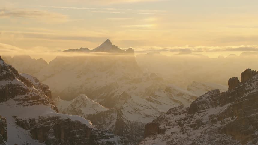 An aerial view of a mountain range covered in snow