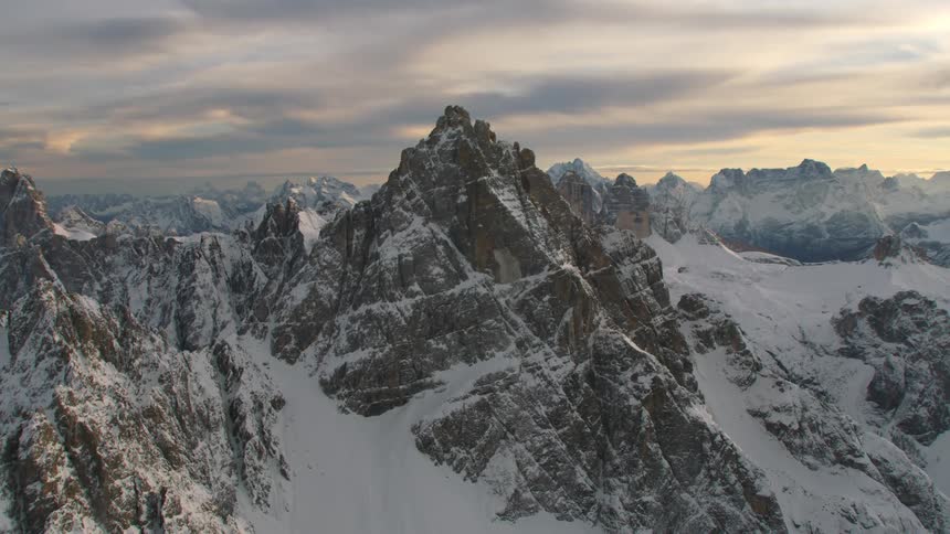 Snow covered mountains with peaks high in a cloudy sky