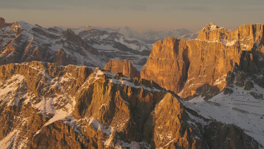 The sun is shining on the snow covered mountain range