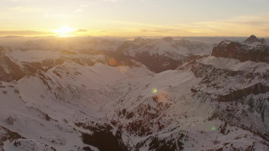 Vast mountain range partially covered in snow in the wilderness at dawn