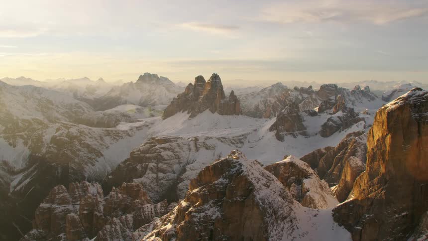 Snowy rugged mountain range sits under cloudy sky