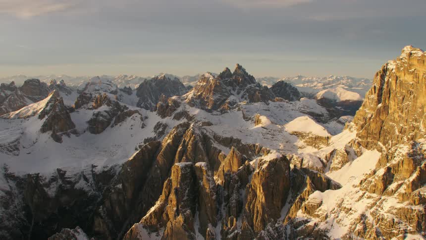 An aerial view of a mountain range with snow on it