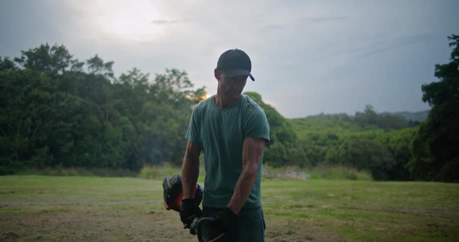 A man working with a weed wacker outdoors