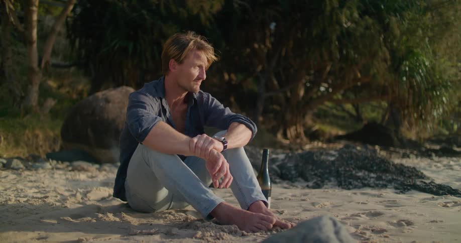 A man sitting out on the beach thinking