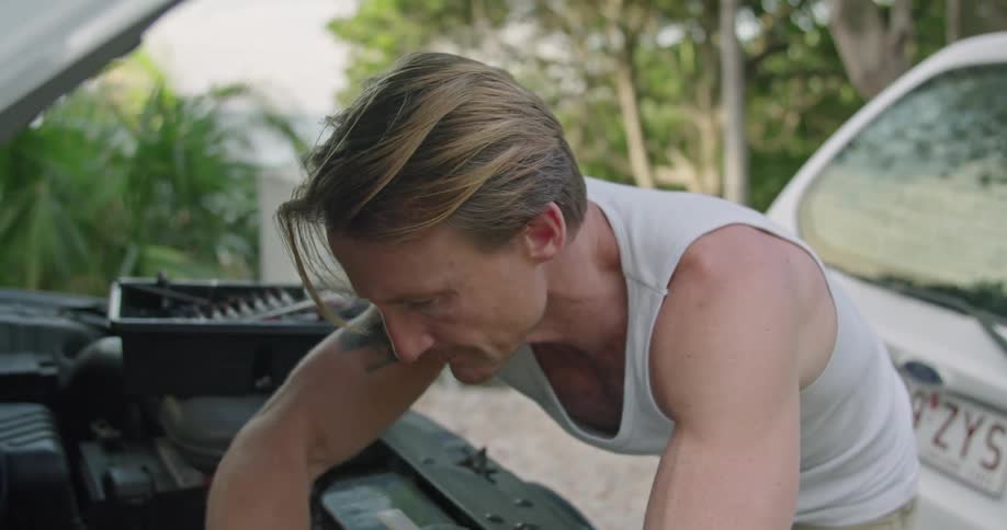 A man working on a cars engine