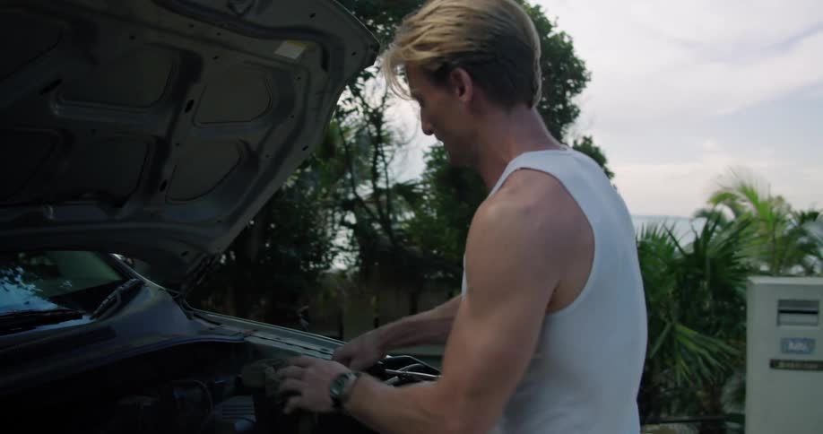 A mechanic walking up to a car to work on it