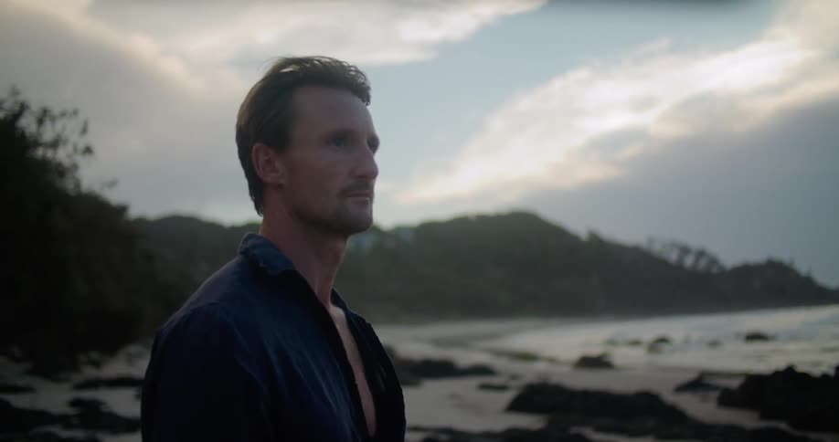 A man standing outdoors on the beach