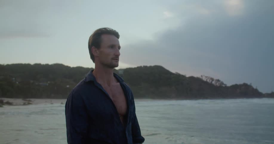A man wearing clothes standing in an ocean