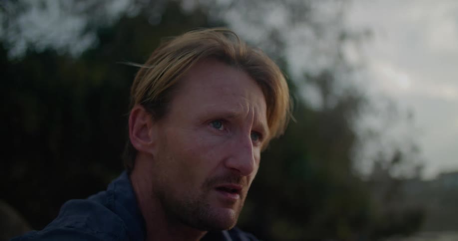 A man begins to cry while sitting outside