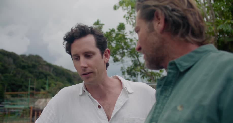 Two men standing outside smiling as they have a meeting and discussion