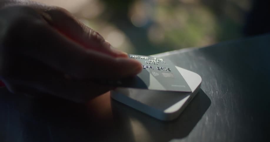 A person pays by tapping their credit card