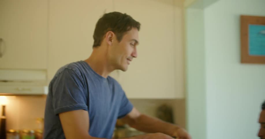 A man smells the food that is cooking in the pan