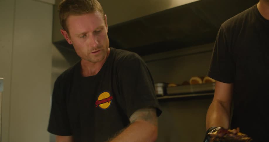 Two men prepare food in the food truck