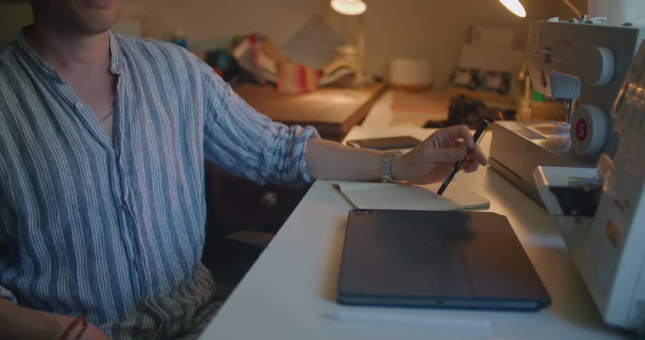 Man sitting at a desk in the office spinning a pen while thinking