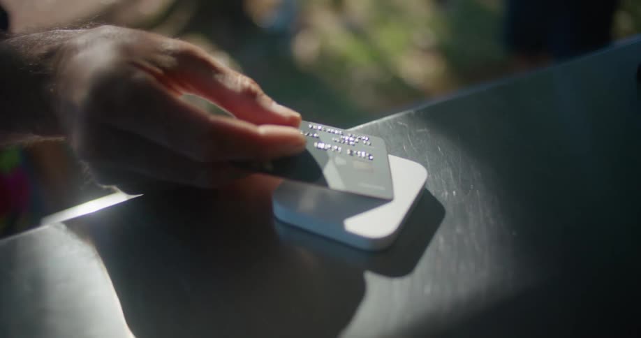 A man taps his credit card on a square chip reader