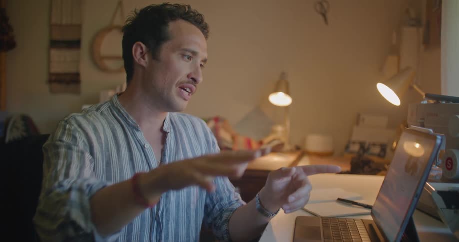 A man sits in his office talking on the tablet