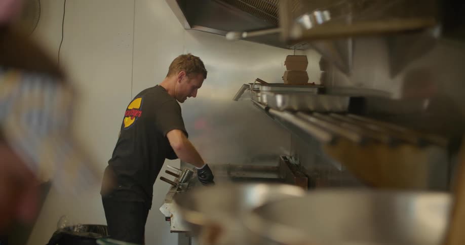 Men are in a restaurant kitchen preparing and cooking food