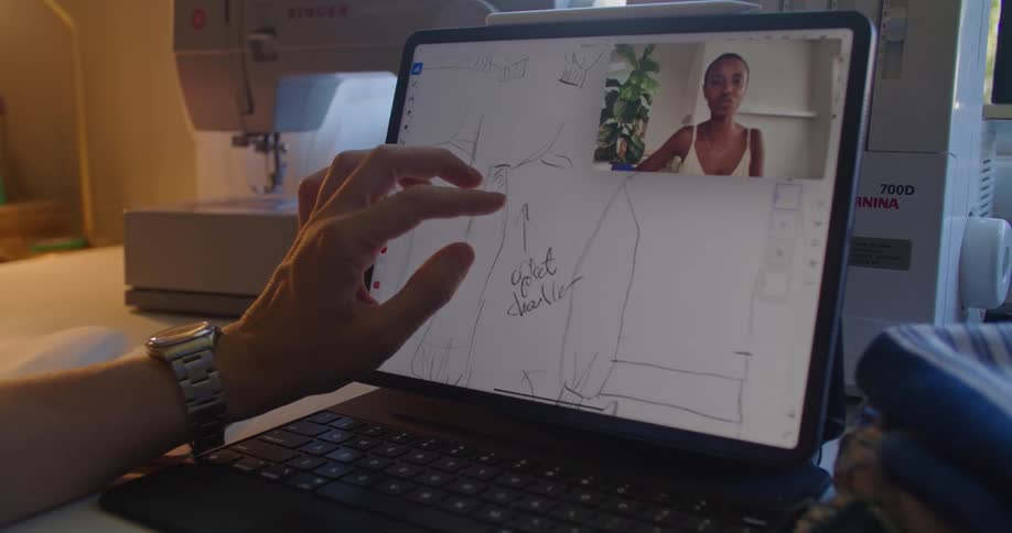 A man and woman discuss sketches while on a video call