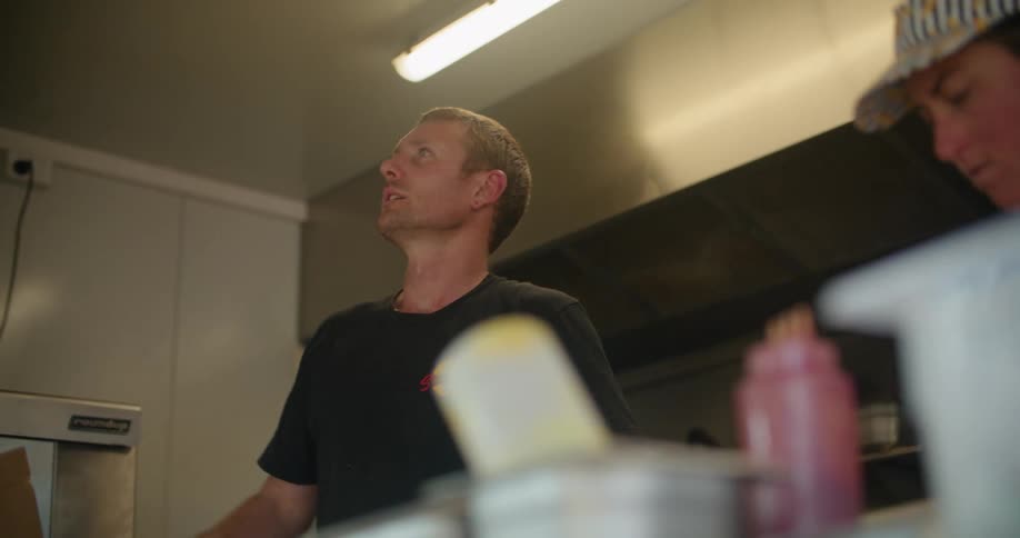 Two cooks talk in the kitchen and prepare food