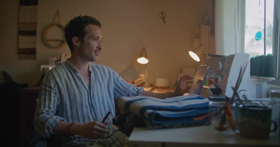 A man is talking and gesturing during an online zoom meeting on a laptop