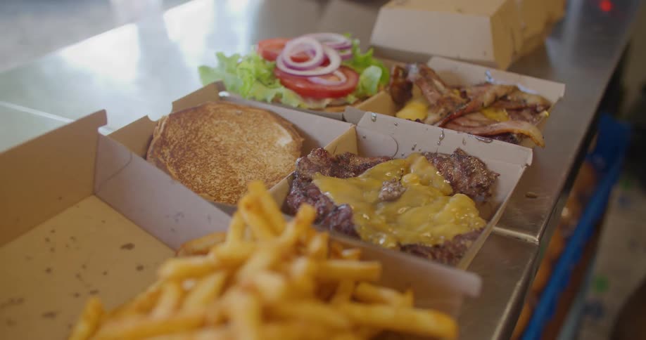 Man places burgers and fries into to go boxes