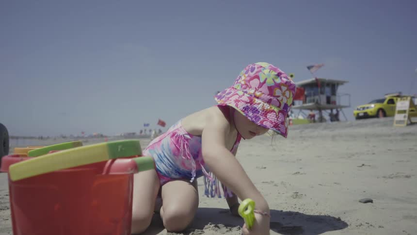 A little girl plays in the sand