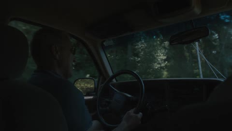 A man drives a car down the street