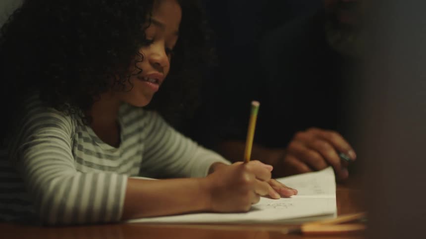 A man is helping the girl with her homework