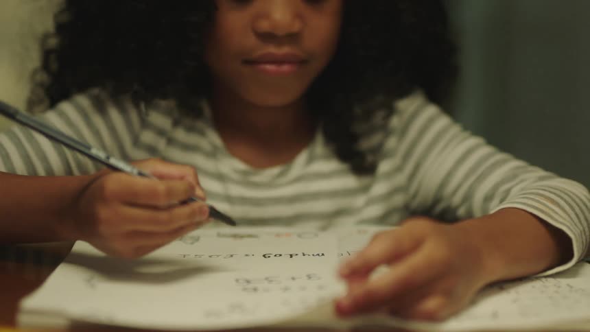 A girl is doing homework at the table