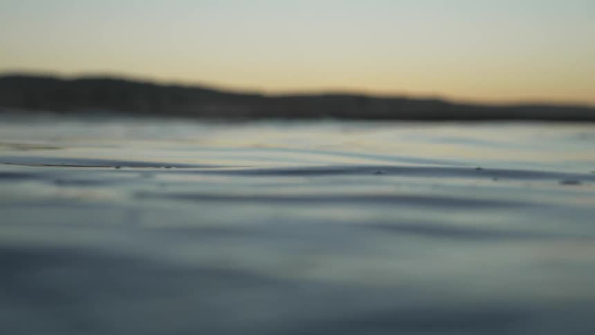 Water ripples and moves with bits of dirt on the surface