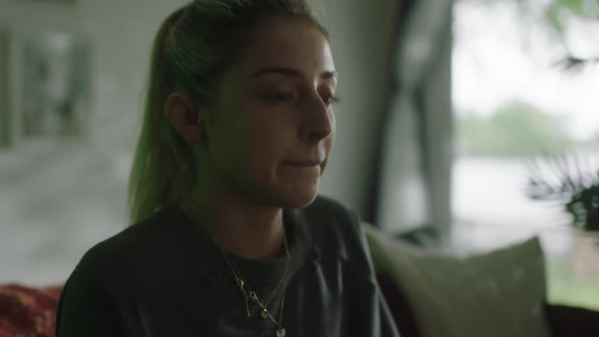 Young frustrated woman sitting on a couch at home playing video games