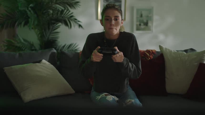 A woman playing a video game cheers