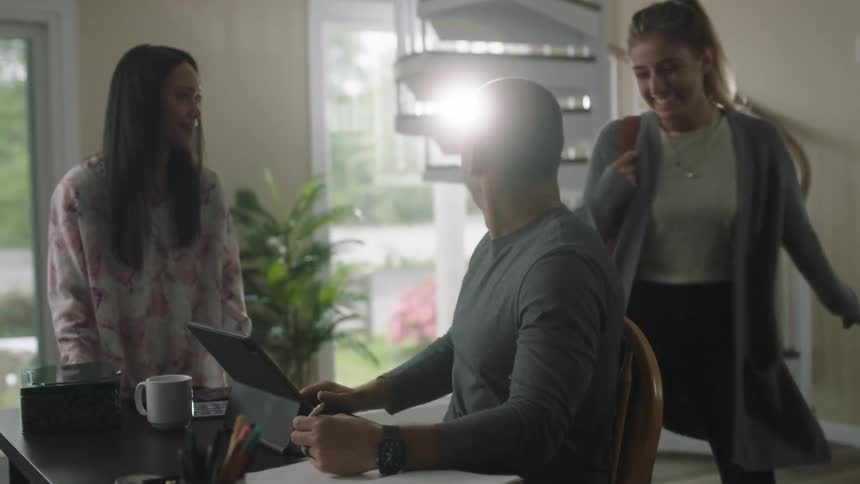 A woman walks down the stairs to a man and woman at a desk