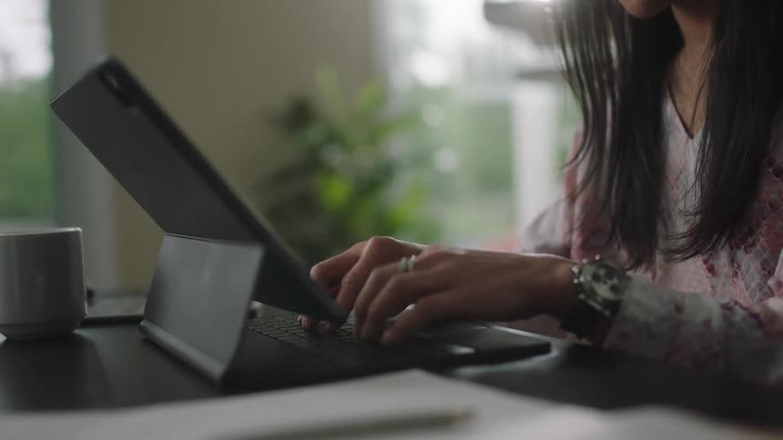 A woman is typing at her desk